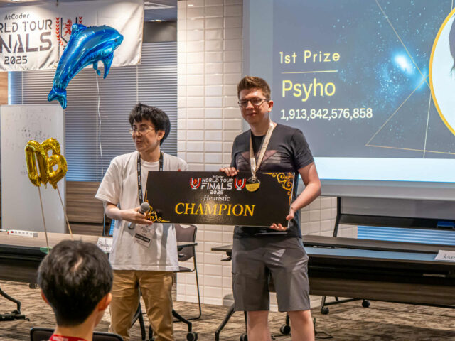 Przemysław Dębiak (right) receives an award for winning the 2025 AtCoder World Finals Heuristic Contest.